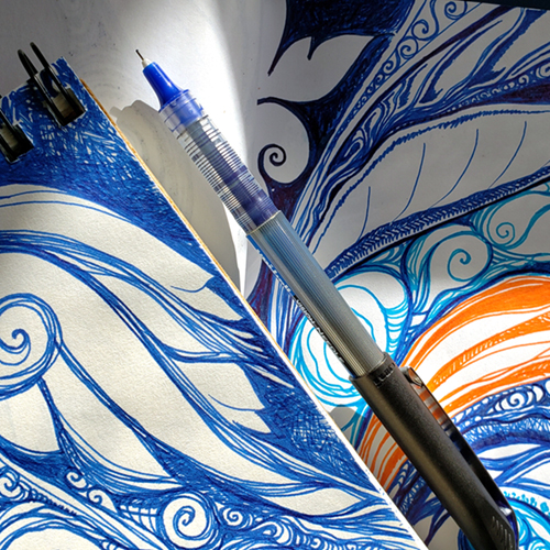 Sunlight shining on a pen and blue spiral designs